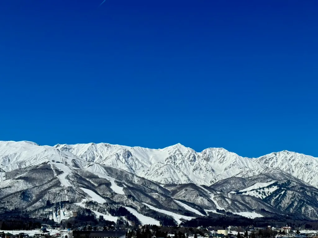 ログハウスから眺める、雪化粧の白馬の山々